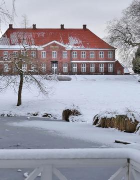 Hindsgavl Slot smukt beliggende i det sneklædte landskab